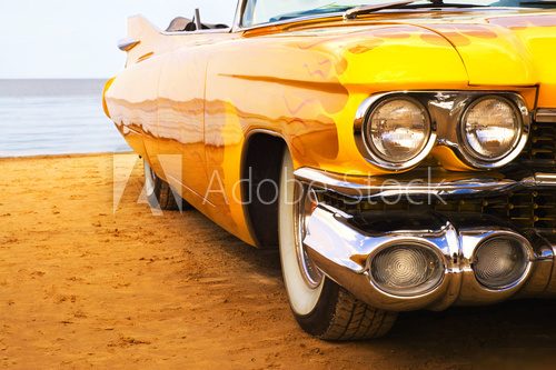 Classic yellow flame painted Cadillac at beach