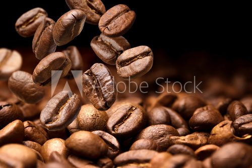 Falling coffee beans. Dark background with copy space, close-up