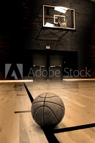 Basketball on court with hoop in the background