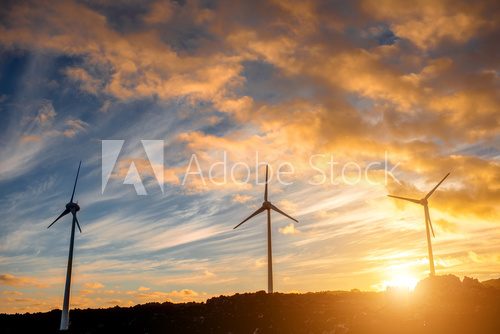 Electric windmills on the sky background on the sunset