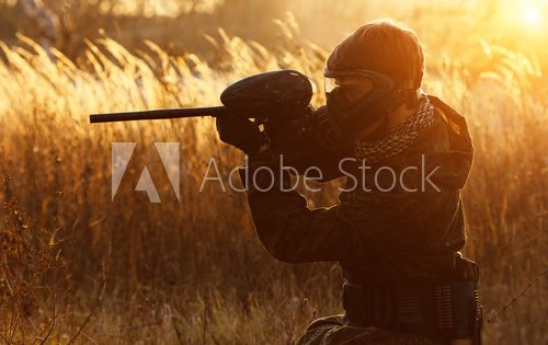 Paintball sport player at sunset 
