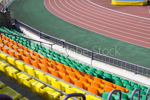 rows of plastic seats at stadium 