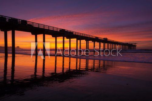Silhouette pier at beach and brilliant sunset