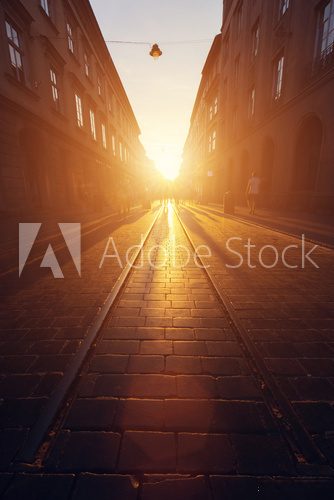 Empty cobblestone street in old town at sunset.