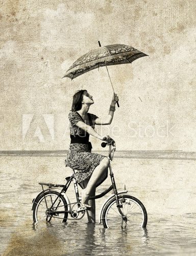 Girl with umbrella on bike Photo in old image style