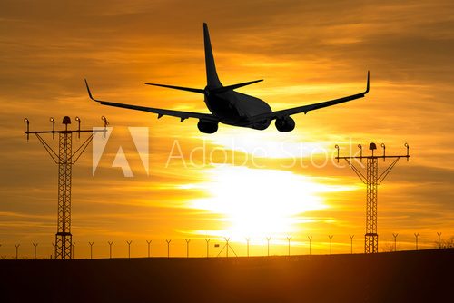 Airplane landing on the runway at sunset 