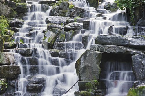 Beautiful waterfall cascades over rocks in lush forest landscape 