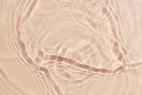 Beige water surface background. Water texture with splashes and bubbles. Summer nature background