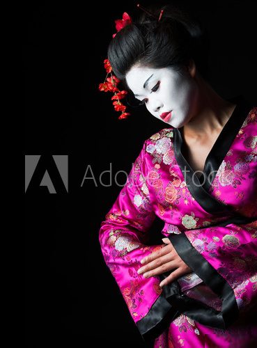 Closeup portrait of geisha isolated on black 