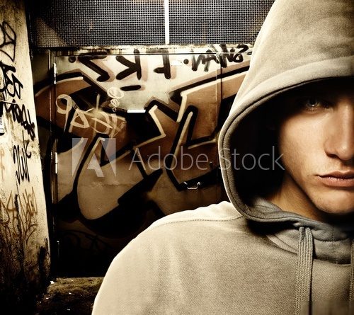 Cool looking hooligan in a graffiti painted gateway