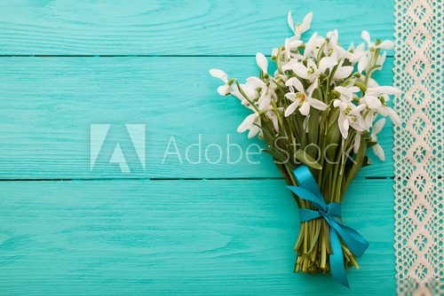 Flowers and lace ribbon on blue wooden background 