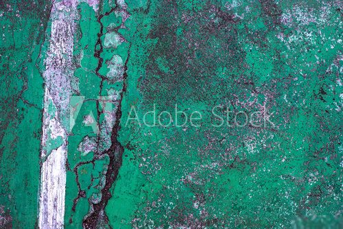 Green cracked asphalt with white line, top view photo. Cement floor top view texture. Rustic surface vintage background