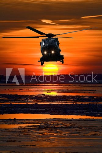 Hubschrauber vor glühendem Sonnenuntergang