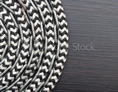 Metal chain and ship rope on dark wooden background