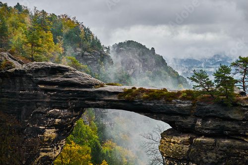 Misty foggy landscape of the Pravcicka gate (Pravcicka brana) the largest natural sandstone arch in Europe in Czech Switzerland (Bohemian Switzerland or Ceske Svycarsko) National Park