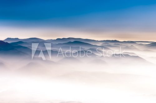 Misty mountains landscape view with blue sky 