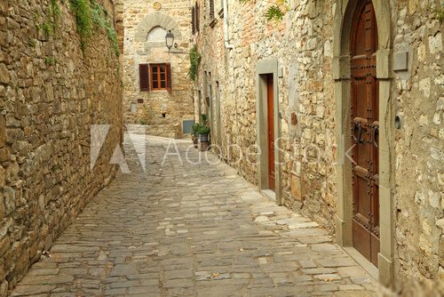 narrow  paved street and stone walls in italian village, Montefi 