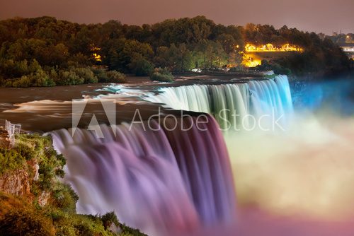 Niagara Falls lit at night by colorful lights 