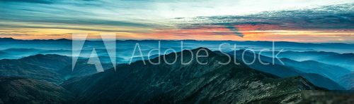 Panorama with blue mountains and hills at sunset