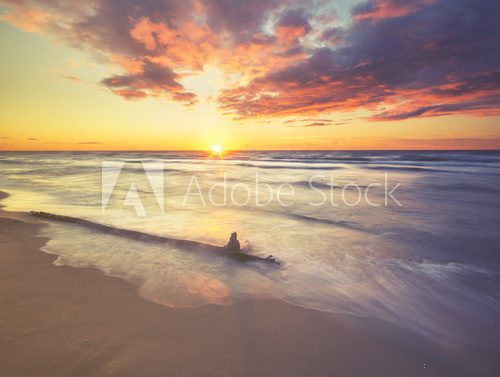 Sea landscape at sunset, sandy beach and cliff,waves breaking on the shore toned with a retro vintage  effect