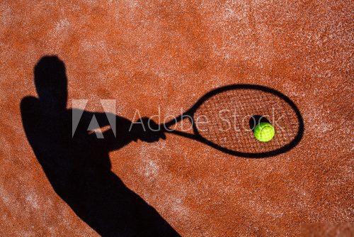 shadow of a tennis player in action on a tennis court  