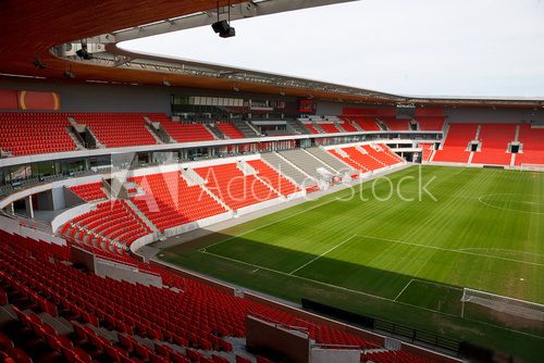 View on an empty football (soccer) stadium with red seats 