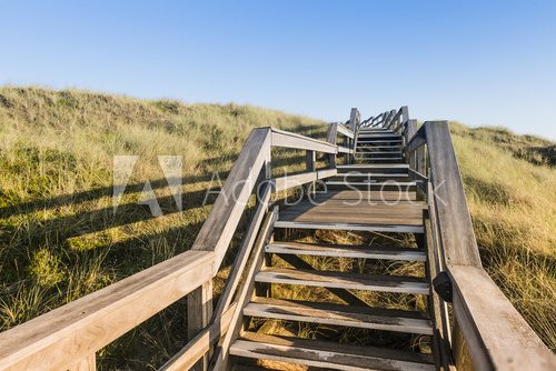 Wooden footpath through dunes at the North sea beach in Germany. 