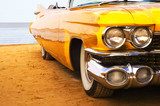 Classic yellow flame painted Cadillac at beach