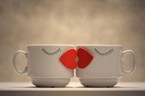 Two coffee cups with red hearts as a kissing lips 