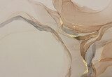 Abstract beige art with gold — pink background with brown, beautiful smudges and stains made with alcohol ink and golden pigment. Beige fluid art texture resembles petals, watercolor or aquarelle.