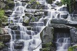 Beautiful waterfall cascades over rocks in lush forest landscape 