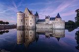 Castle chateau de Sully-sur-Loire at night, France. Mirror reflection in river.