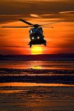 Hubschrauber vor glühendem Sonnenuntergang
