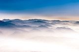 Misty mountains landscape view with blue sky 