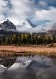 Mount Assiniboine with autumn forest reflection on Lake Magog at provincial park
