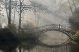 Old bridge in misty autumn park
