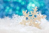 Snowflake on snow against holiday lights background. 