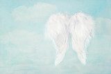 White angel wings on blue sky background 