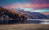 Wonderful autumn landscape during sunset. Fairy tale moutain lake with picturesque sky, majestic rocky mount and colorful trees at sunlight. Amazing nature scenery. Champfer lake. Switzerland Alps